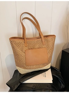 Two-tone woven straw tote bag with brown leather handles and decorative patch for summer