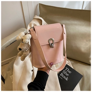 Gros plan du sac seau en cuir verni rose avec boucle argentée et charm chien perlé