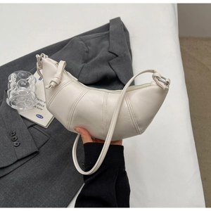 Close-up of off-white croissant bag featuring pleated details and knotted strap design