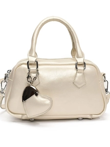 Champagne metallic bowling handbag with heart charm and silver hardware on white background
