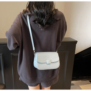 Close-up of mint green vintage soft leather crossbody bag with square buckle detail on model