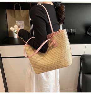 Détail des anses en cuir rose et texture tressée sur un grand sac cabas de plage