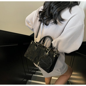 Détail du sac fourre-tout noir plissé avec ferrures dorées et mini pochette ronde