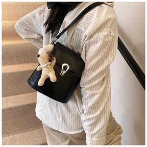 Détail du sac seau noir avec boucle fer à cheval argentée et breloque en peluche