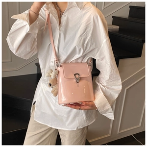 Détail du sac seau en cuir verni rose brillant avec fermoir métal et breloque peluche