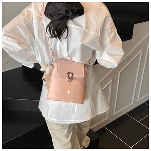 Détail du sac seau en cuir verni rose avec fermoir argenté et breloque chien