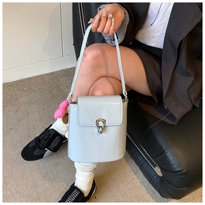Détail du sac seau en cuir verni bleu clair avec fermoir métallique en fer à cheval