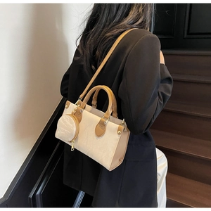 Détail du sac cabas beige élégant avec bordure en cuir marron et mini pochette