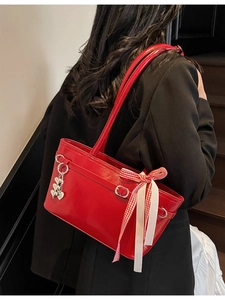 Grand sac cabas rouge vif avec pendentif en cœur et ruban porté à l'épaule sur mannequin