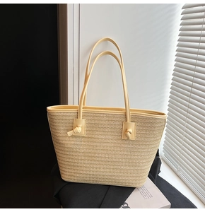 Détail du sac cabas en paille tressée avec un design élégant de poignée en cuir noué