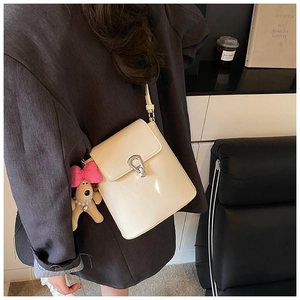 Détail du sac seau blanc crème avec fermoir fer à cheval et breloque chiot en peluche