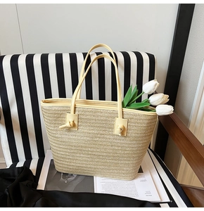 Détail du sac cabas beige tressé montrant les poignées en cuir nouées et la paille