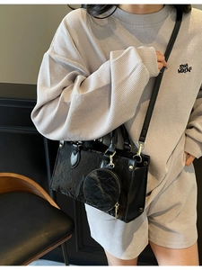 Sac à main noir minimaliste avec texture froissée, doubles anses et porte-monnaie rond