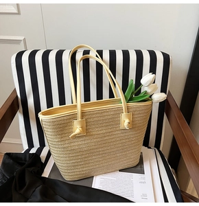 Détails d'un sac cabas en paille avec des anses en cuir et boucle décorative nouée