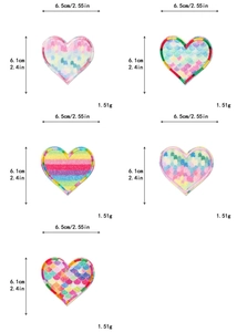 Dettaglio macro di toppe a cuore glitter arcobaleno 6,5x6,1 cm con motivi a scaglie