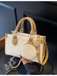 Sac à main bicolore beige et marron avec pochette ronde et détails dorés brillants