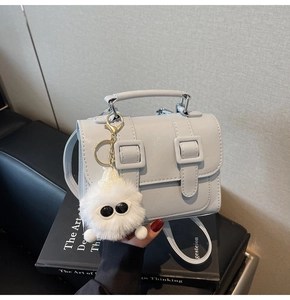 Light blue faux leather satchel bag with cute plush monster charm and top handle