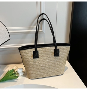 Détail du sac cabas en paille avec lanières en cuir noir et boucle de renfort élégante