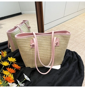 Détail du sac cabas d'été en paille avec bandoulière en cuir rose et nœud décoratif