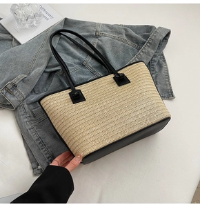 Détail du sac cabas en paille tissée avec base et poignées en similicuir noir