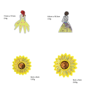 Dettaglio delle toppe ricamate con paillettes a forma di ragazza e girasole con misure