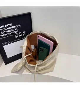 Interior view of minimalist cream tote bag showing capacity for tablet and water bottle