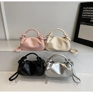 Detail view of ruched cloud handbags in pink, white, black, and silver metallic finishes