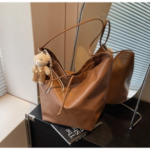 Detalle del bolso tote marrón vintage con un lindo colgante de peluche de osito café