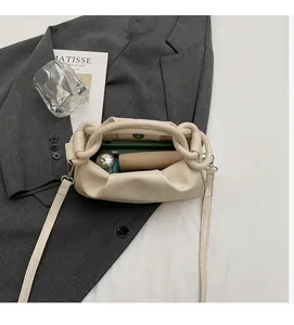 Macro top view showing spacious inner compartment of the beige pleated cloud crossbody bag