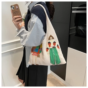 Detailaufnahme der beigen Stricktasche mit bunter Stickerei modischer Mädchen