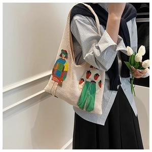 Detail der Strick-Tote-Bag mit kunstvoller Stickerei und gewebter Materialstruktur