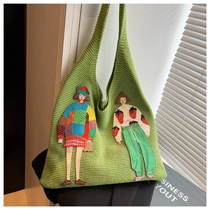 Detail der grünen Stricktasche mit Textur und Cartoon-Charakter-Stickerei-Design