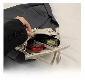 Detail view of the spacious inner compartment of the cream square crossbody handbag