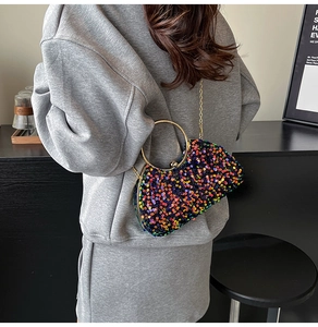 Detail of sequin evening bag with gold ring handle and metallic chain strap