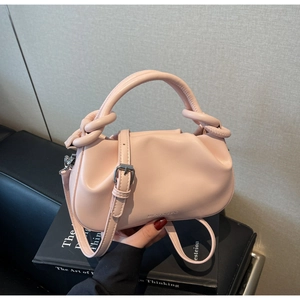 Close-up of pink cloud handbag showing knotted handle and silver metal buckle