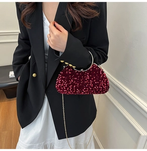 Detail of burgundy sequin evening bag with gold circular handle and chain strap