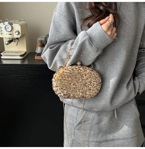 Detailed shot of golden sequin evening clutch featuring a sparkling rhinestone sphere clasp