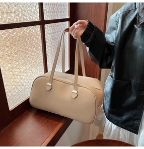 Detail of apricot lychee pattern leather shoulder bag with sleek silver hardware accents