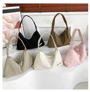 Detailed close-up of colorful pleated canvas tote bags in a minimalist studio setup