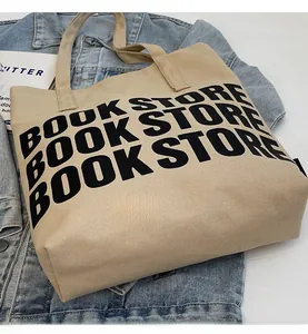 Vue détaillée du sac fourre-tout en toile beige avec imprimé Book Store noir sur jean bleu