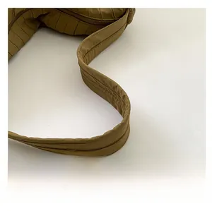Close-up of pleated nylon shoulder bag strap detail in olive brown finish