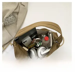 Top view showing large capacity of brown pleated shoulder bag with tablet and daily essentials