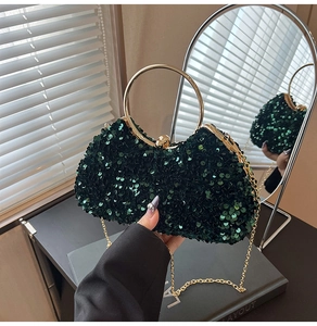 Detail view of dark green sequin evening clutch with golden ring handle and chain