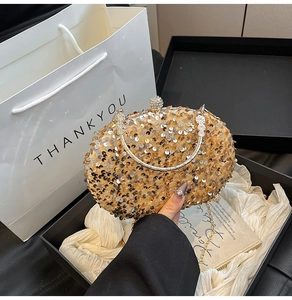 Close-up of champagne gold sequined evening bag with diamond clasp and metal handle