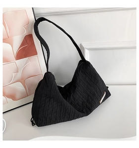 Detail showing vertical pleated texture and zipper on the black nylon cloud bag