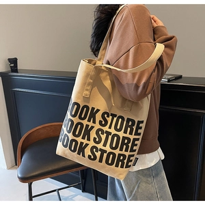 Vue détaillée du sac cabas en toile beige avec imprimé lettres noires et larges anses