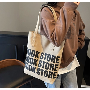 Gros plan du texte BOOK STORE sur un sac fourre-tout en toile beige avec étiquette