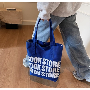 Vue latérale d'un sac cabas en toile bleu roi avec lettrage blanc BOOK STORE