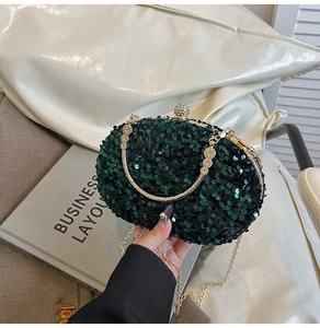 Detail of emerald green sequin evening bag with gold handle and sparkling texture