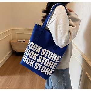 Détail du sac cabas en toile bleu roi avec typographie BOOK STORE blanche